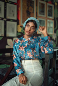 蓝花衬衫女子优雅坐姿肖像
