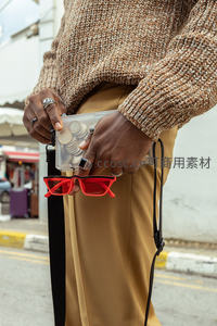 街头时尚达人手拿透明包与红墨镜