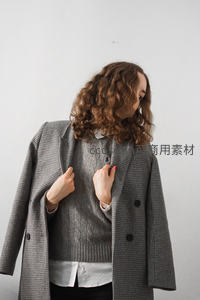 卷发女子整理格纹大衣