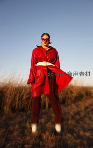 红衣女子田野中昂首，风扬衣袂