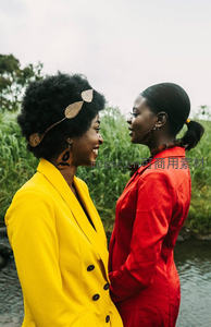 两位女士户外对视，黄红外套显活力