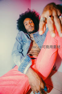 卷发男子霓虹光影下的时尚姿态