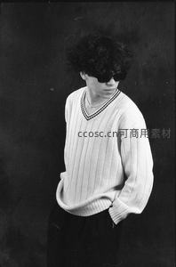卷发青年戴墨镜穿V领毛衣