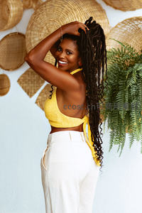 阳光女孩笑对镜头，黄色编织上衣搭配自然背景