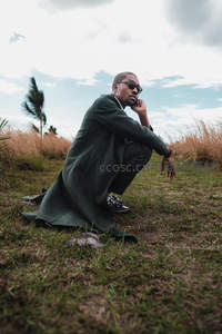 草地沉思的西装男子