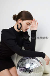 黑衣女子倚靠银色迪斯科球沉思