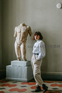 一女子手放口袋站在雕像前合影