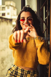 阳光窗边微笑女子指向镜头