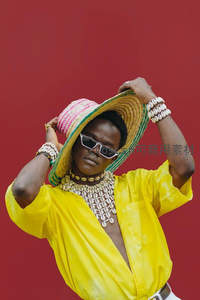 非洲风情时尚造型，色彩鲜艳的草帽与贝壳饰品