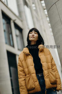 街头时尚女孩身穿黄色羽绒服