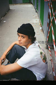 巷道少年坐姿，卡通印花白T黑帽