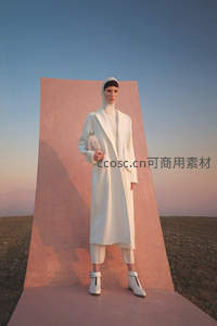 白色大衣模特立于粉墙前
