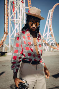 游乐园前的时尚摄影师，复古风潮尽显个性