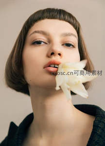 白花轻触唇边，少女眼神清澈如诗如画