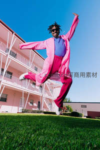 粉衣男子跃动草坪之上