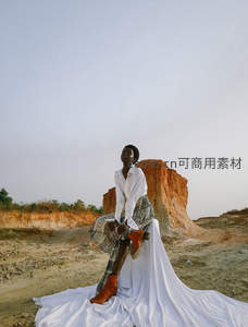 红土崖边白衣女子静坐凝望