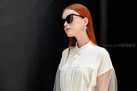 红发女子戴墨镜侧脸特写