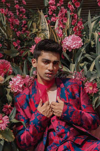 花丛中的时尚男士，红蓝印花西装引人注目