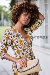 非洲印花裙女子，卷发迷人手提编织包