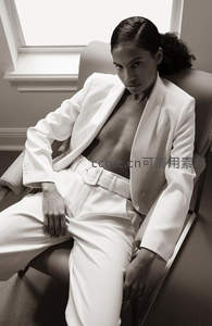 黑白影像中白西装女性坐椅凝视