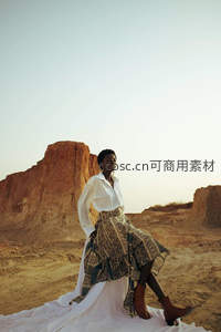 沙漠中的时尚姿态，白色衬衫与印花长裙的优雅碰撞