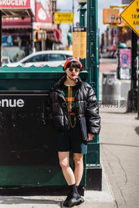 街头时尚达人倚靠绿色垃圾桶