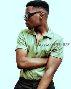 绿衫青年侧颜沉思，墨镜遮面显酷感