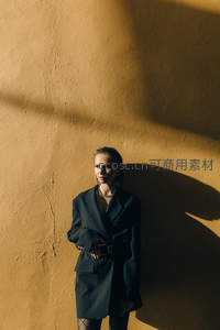 女子倚墙光影斑驳显沉静气质