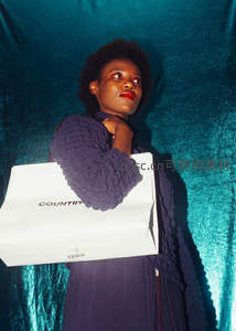 紫衣女子手提购物袋仰望