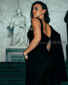 黑衣女子回眸凝望古典雕像