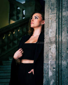 女子倚靠石柱仰望楼梯深处