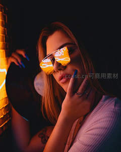 霓虹光影下戴炫酷墨镜的少女