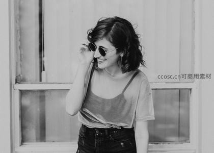 微笑女子扶墨镜，窗前阳光洒落