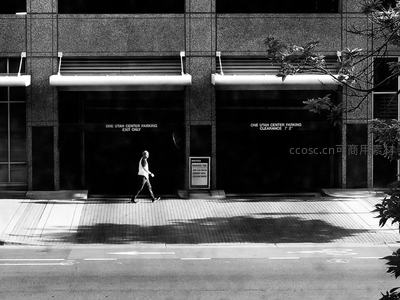 黑白街景中行人走过现代建筑入口