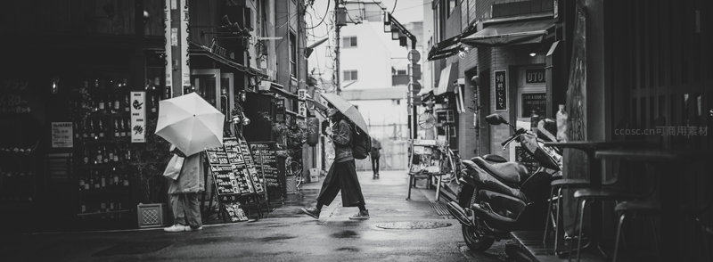 雨巷行人撑伞穿行的日常景象