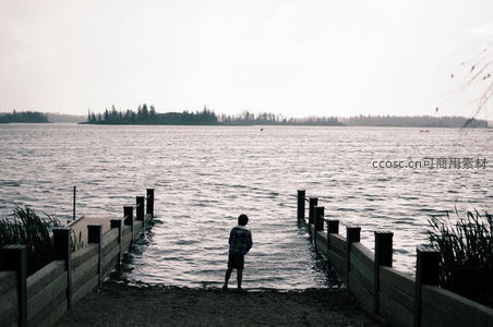 湖边少年凝望远方宁静水域