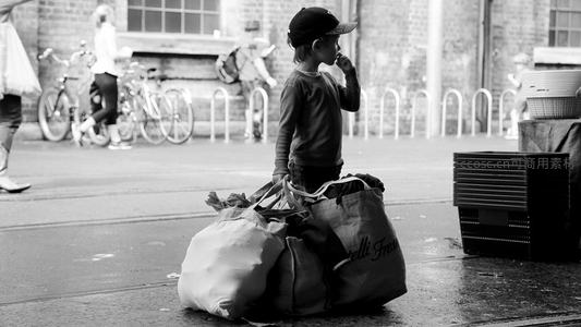 街角孩童手提购物袋沉思