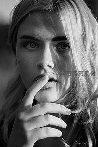 光影下的少女，指尖轻触唇边的静谧