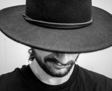 宽檐帽下神秘微笑，只露胡须的绅士剪影