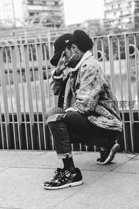 街头女孩蹲坐栏杆旁摆酷手势街拍