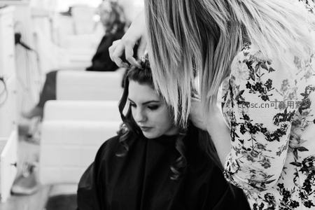 发型师为顾客精心打理卷发的黑白瞬间