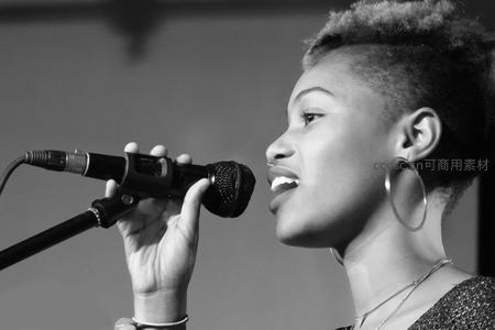 女歌手侧脸深情献唱于麦克风前