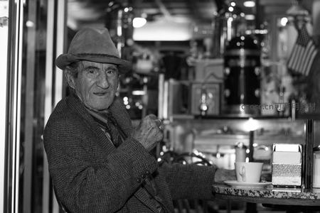 咖啡馆里戴帽老人的温暖微笑