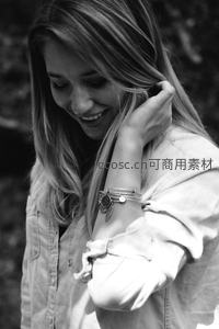 微笑女子手抚发丝特写黑白照