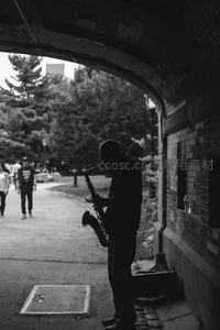 拱门下萨克斯街头艺人剪影