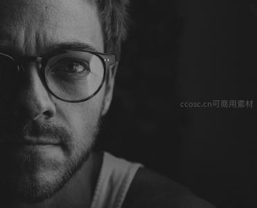 戴眼镜男子凝视镜头的深邃眼神