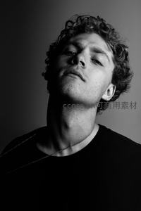 卷发男子仰望，光影雕刻轮廓