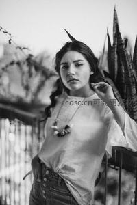 少女倚靠植物凝视镜头