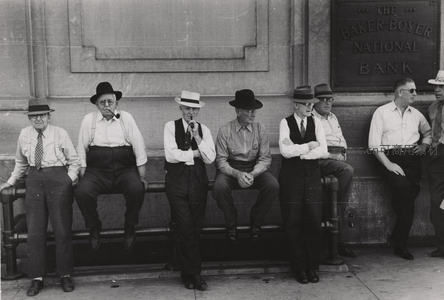 一群时尚复古穿着老人在银行门口合影