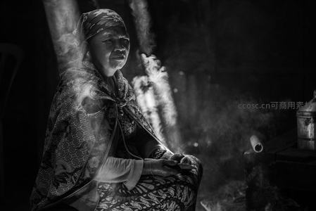 炊烟袅袅中静坐的老妇人